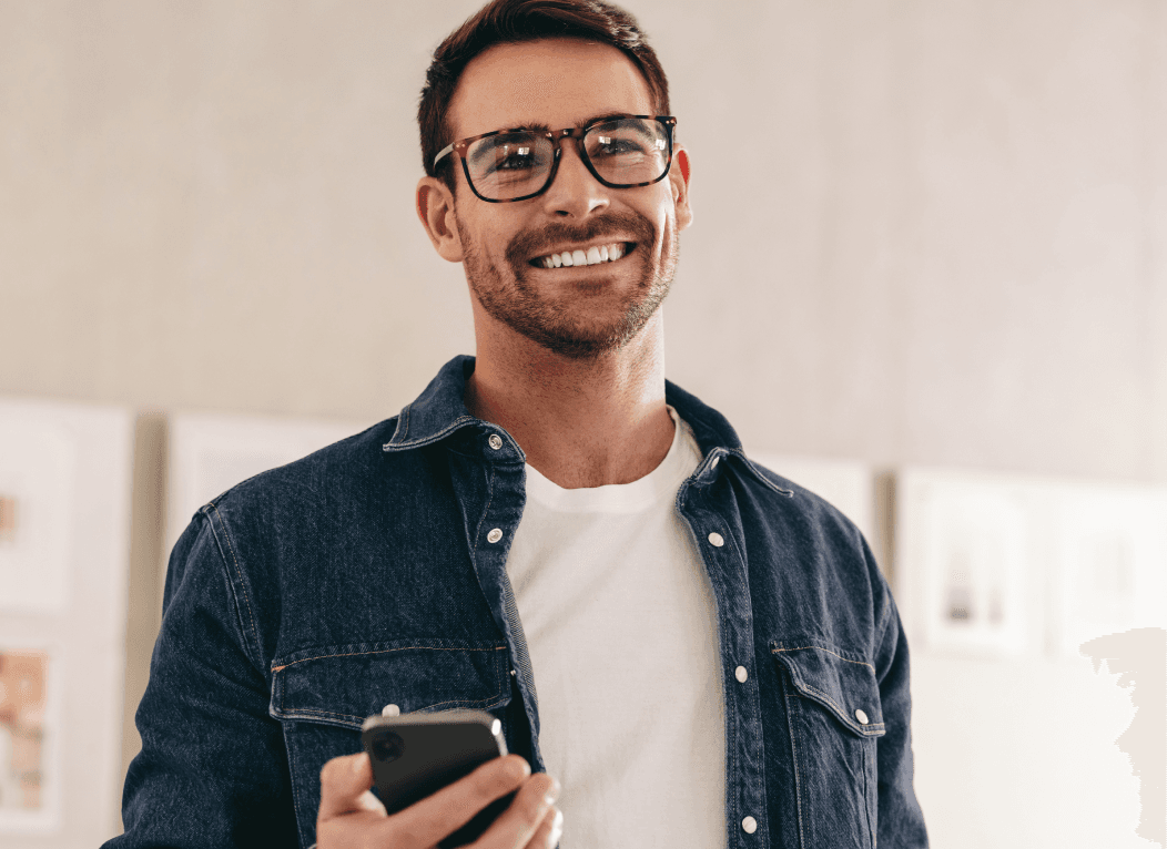 Imagem de um homem sorrindo segurando o celular